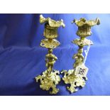 A PAIR OF ORNATE BRASS CANDLESTICKS IN THE FORM OF A PEASANT GIRL AND PEASANT BOY