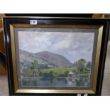 A LARGE FRAMED AND GLAZED OIL ON CANVAS OF A LAKESIDE SCENE WITH MOUNTAINS IN THE BACKGROUND