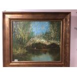 A LARGE GILT FRAMED OIL ON CANVAS OF A WATERSIDE AFRICAN SCENE WITH BOATMEN IN RUSHES SIGNED M