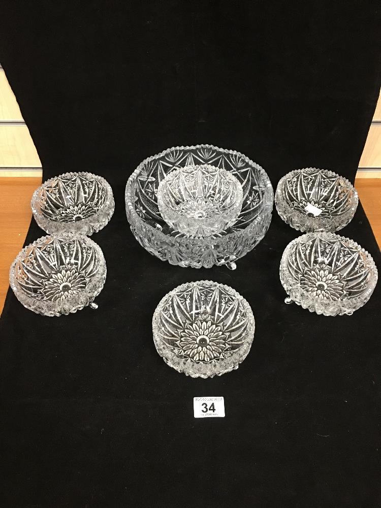 A CUT GLASS FRUIT BOWL AND SIX GLASS BOWLS, EACH RAISED UPON THREE GLASS FEET