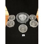 A CUT GLASS FRUIT BOWL AND SIX GLASS BOWLS, EACH RAISED UPON THREE GLASS FEET