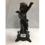 A LATE 19TH CENTURY BRONZE FIGURE OF A SEATED CHERUB PERCHED UPON A PEDESTAL BASE, 31CM HIGH