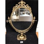 A GILT BRASS DRESSING TABLE MIRROR OF OVAL FORM, RAISED ON CIRCULAR PEDESTAL BASE, 56CM HIGH