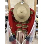 A MILITARY RED DRESS UNIFORM AND A PITH HELMET, LABEL TO INSIDE OF UNIFORM READS OPERA NORTH STAGE