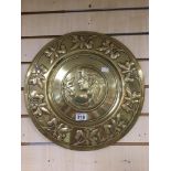 AN ART NOUVEAU BRASS CHARGER OF CIRCULAR FORM WITH HAMMERED DECORATION OF A LADY WITH FOLIAGE