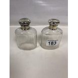 A PAIR OF EARLY 20TH CENTURY SILVER LIDDED CUT GLASS TOILETRY BOTTLES, HALLMARKED LONDON 1911,