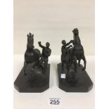 A PAIR OF BRONZE FIGURE GROUPS OF HORSES BEING TAMED BY THEIR HANDLERS, RAISED ON BLACK METAL