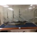 A LARGE PLASTIC MODEL THREE MASTED SHIP IN EXTREMELY LARGE GLASS CASE ON WOODEN BASE, 109CM BY 41CM