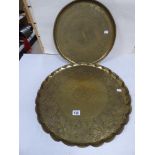 A LARGE MIDDLE EASTERN BRASS TRAY OF CIRCULAR FORM, 54.5CM DIAMETER, TOGETHER WITH A SMALLER