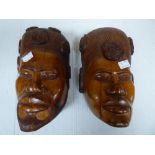 A PAIR OF CARVED HARD WOOD MADAGASCAN FACE WALL MASKS OF A MAN AND WOMEN , 24CM IN LENGTH