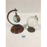 A VINTAGE GLASS BALL SHAPED POCKET WATCH ON HANGING STAND, TOGETHER WITH A SMALL GLASS DESK GLOBE