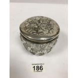 AN EDWARDIAN SILVER TOPPED CUT GLASS POWDER BOWL, THE LID EMBOSSED WITH REYNOLDS ANGLES,