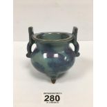 AN EARLY CHINESE POTTERY BLUE GLAZED TWIN HANDLED INCENSE BURNER RAISED UPON THREE FEET, 11.2CM HIGH