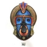 A VIBRANTLY PAINTED CERAMIC TRIBAL WALL MASK, SIGNED TO REVERSE "CUBA" 34CM LONG