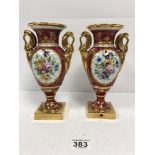 A PAIR OF FRENCH PORCELAIN DECORATIVE TWIN HANDLED URNS WITH FLORAL AND GILT DETAILING THROUGHOUT,