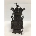 AN ANTIQUE CHINESE HEAVY BRONZE LIDDED POT WITH HEAVILY EMBOSSED DECORATION THROUGHOUT, CRANE FINIAL