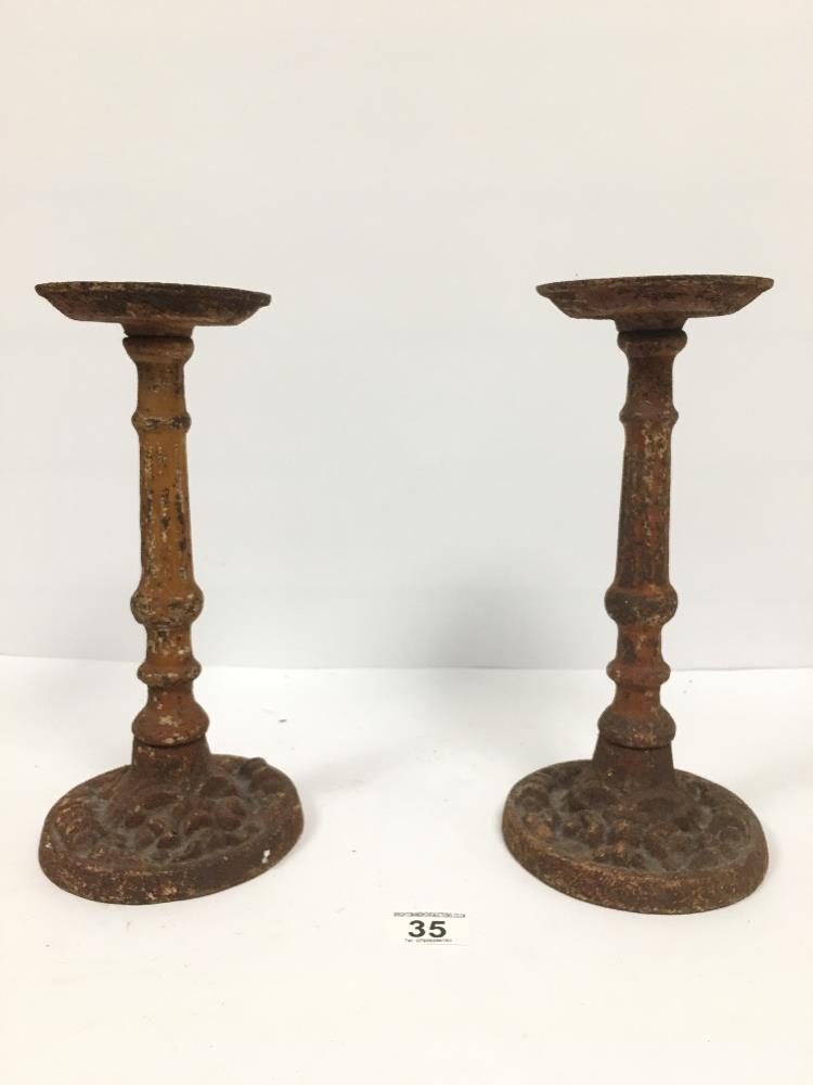 A PAIR OF SMALL HEAVY CAST IRON SPIT CANDLESTICKS, 29.5CM HIGH