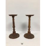 A PAIR OF SMALL HEAVY CAST IRON SPIT CANDLESTICKS, 29CM HIGH