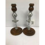 A PAIR OF WOODEN CANDLESTICKS WITH CHROME BALLERINA CENTRAL SUPPORTS, REG DESIGN 874839, 21CM HIGH