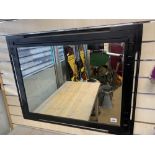 A BLACK FRAMED MIRROR OF RECTANGULAR FORM, 81.5CM WIDE