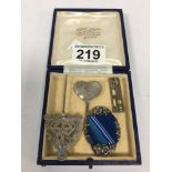 AN ART NOUVEAU SILVER HEART SHAPED PENDANT, TWO SILVER BROOCHES AND AN ENGRAVED SILVER CLOAK PIN,