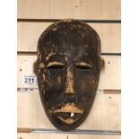 AN AFRICAN CARVED WOODEN TRIBAL MASK, THE MOUTH CONTAINING A SINGLE TOOTH, 26CM HIGH