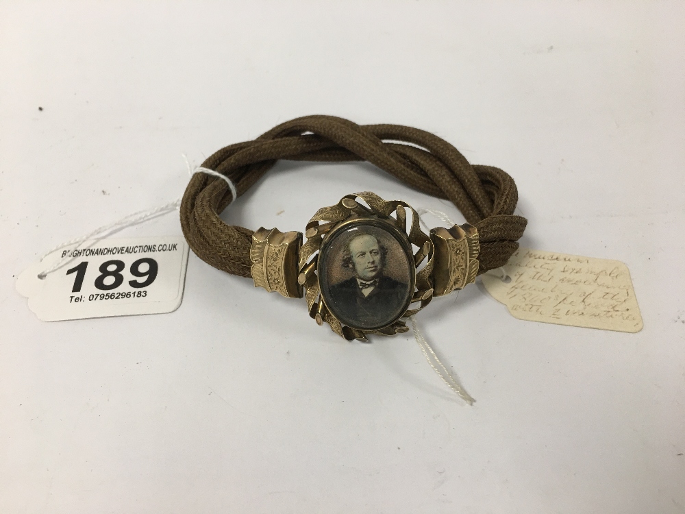 A LATE 19TH CENTURY YELLOW METAL AND FABRIC BRACELET WITH TWO OVAL PICTURE MOMENTO'S, ONE ON EACH