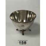 AN AMERICAN STERLING SILVER CIRCULAR SUGAR BOWL WITH BEADED BORDER, RAISED UPON FOUR SCROLLING FEET,