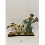 AN UNUSUAL LARGE 1930'S PAINTED PLASTER FIGURE OF AN ELEGANT LADY WALKING TWO BORZOI DOGS, MADE BY