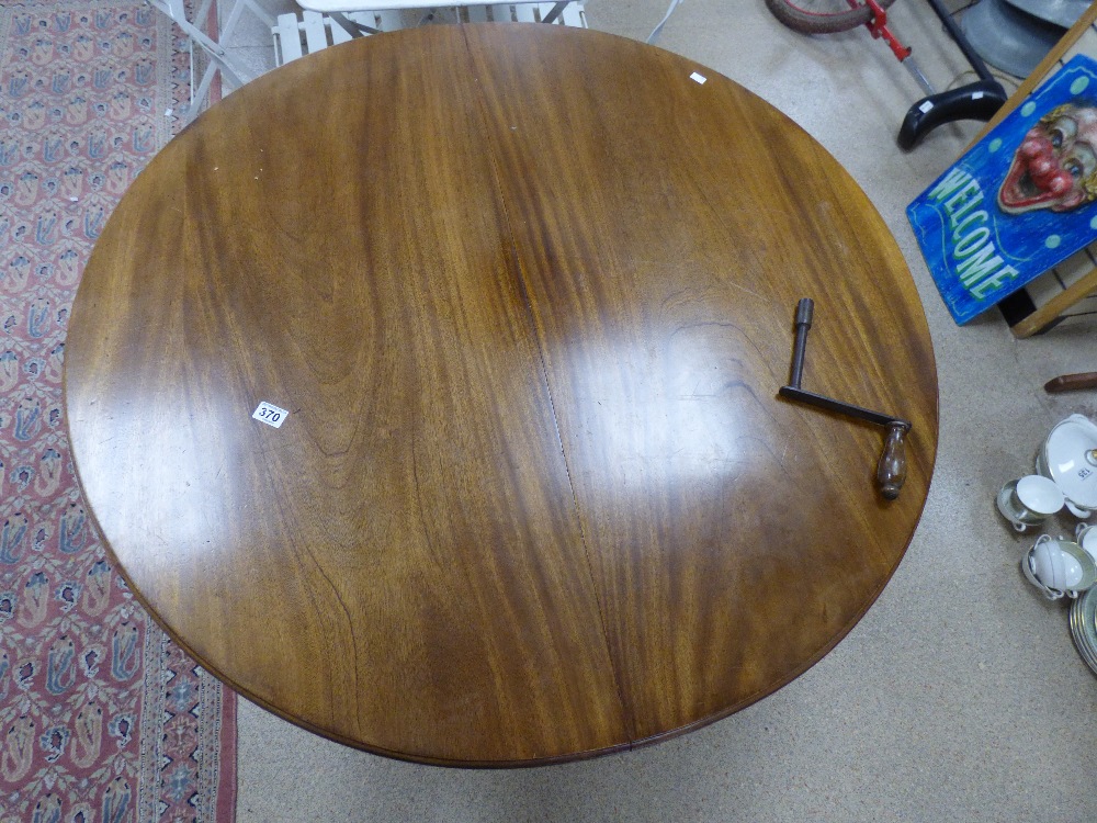 A VICTORIAN WIND OUT MAHOGANY DINING TABLE ON ORIGINAL CASTORS WITH EXTENDING LEAF