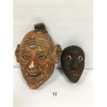 A GROTESQUE PLASTER FACE MASK, 30CM LONG, TOGETHER WITH A CARVED WOODEN FACE MASK