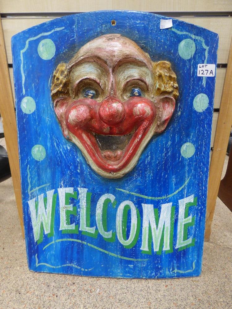 A WEILOMS SIGN WITH A CARVIN OF A CLOWN 44 X 62 CMS