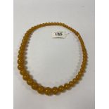 A 1930'S COPAL AMBER BEAD NECKLACE OF GRADUATING FORM, LARGEST BEADS APPROXIMATELY 15MM DIAMETER,