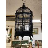A BLACK PAINTED WOODEN BIRDCAGE