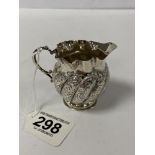 A LATE VICTORIAN SILVER CREAM JUG WITH HEAVILY EMBOSSED DETAILING THROUGHOUT, HALLMARKED