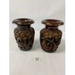 A PAIR OF CARVED WOODEN VASES SHOWING ELEPHANTS AMONGST TREES AND HOUSES, 20CM HIGH