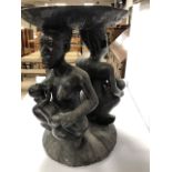 AN AUTHENTIC AFRICAN VINTAGE CARVED FERTILITY TABLE DEPICTING MOTHERS FEEDING THEIR BABIES FROM A