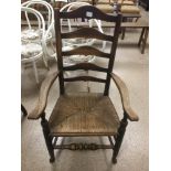 A EARLY RUSTIC LADDER BACK ARMCHAIR IN OAK