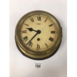 A LARGE BRASS BULKHEAD WALL CLOCK, MADE IN ENGLAND, MOUNTED TO WOODEN BACK, 25CM DIAMETER