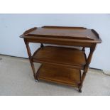 AN ERCOL GOLDEN DAWN THREE TIER ELM TEA TROLLEY 82X48X77CMS.