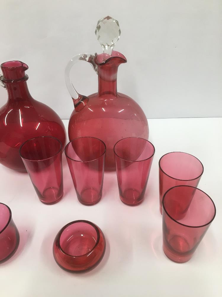 A GROUP OF CRANBERRY GLASS ITEMS, INCLUDING TWO DECANTERS AND DRINKING GLASSES, LARGEST 25.5CM HIGH - Image 2 of 3
