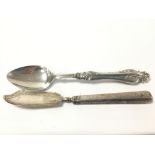 A GEORGIAN SILVER BUTTER KNIFE TOGETHER WITH A VICTORIAN SILVER SPOON WITH HIGHLY ENGRAVED BOWL