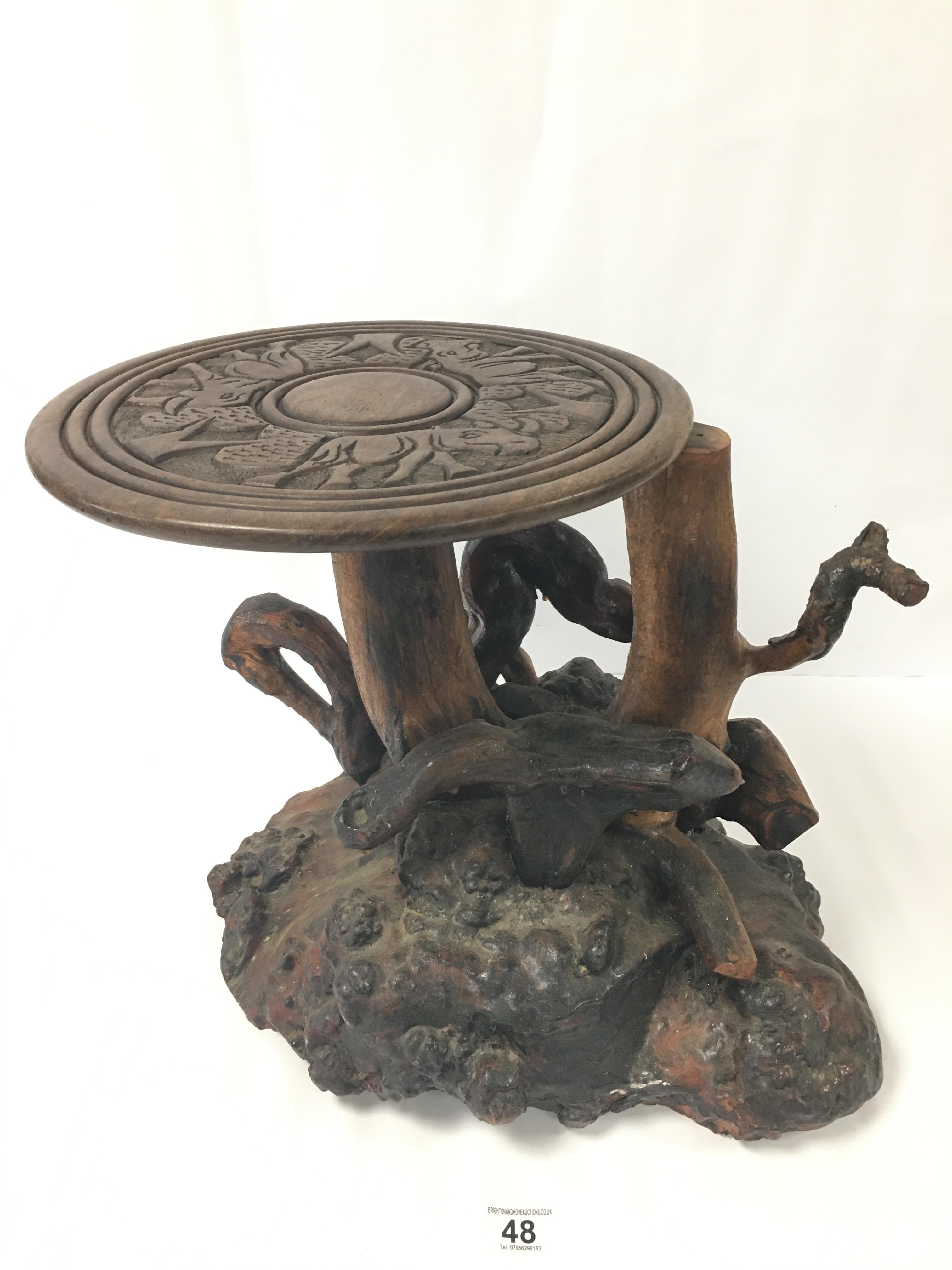 AN UNUSUAL AFRICAN SOLID WOOD HEAVY TABLE MADE FROM A TREE TRUNK AND ROOTS WITH REMOVABLE CARVED