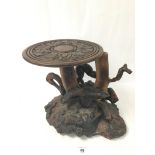 AN UNUSUAL AFRICAN SOLID WOOD HEAVY TABLE MADE FROM A TREE TRUNK AND ROOTS WITH REMOVABLE CARVED