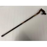 A NOVELTY ORIENTAL WOODEN WALKING STICK WITH CLOISONNE ENAMEL DETAILING, THE HANDLE IN THE FORM OF A