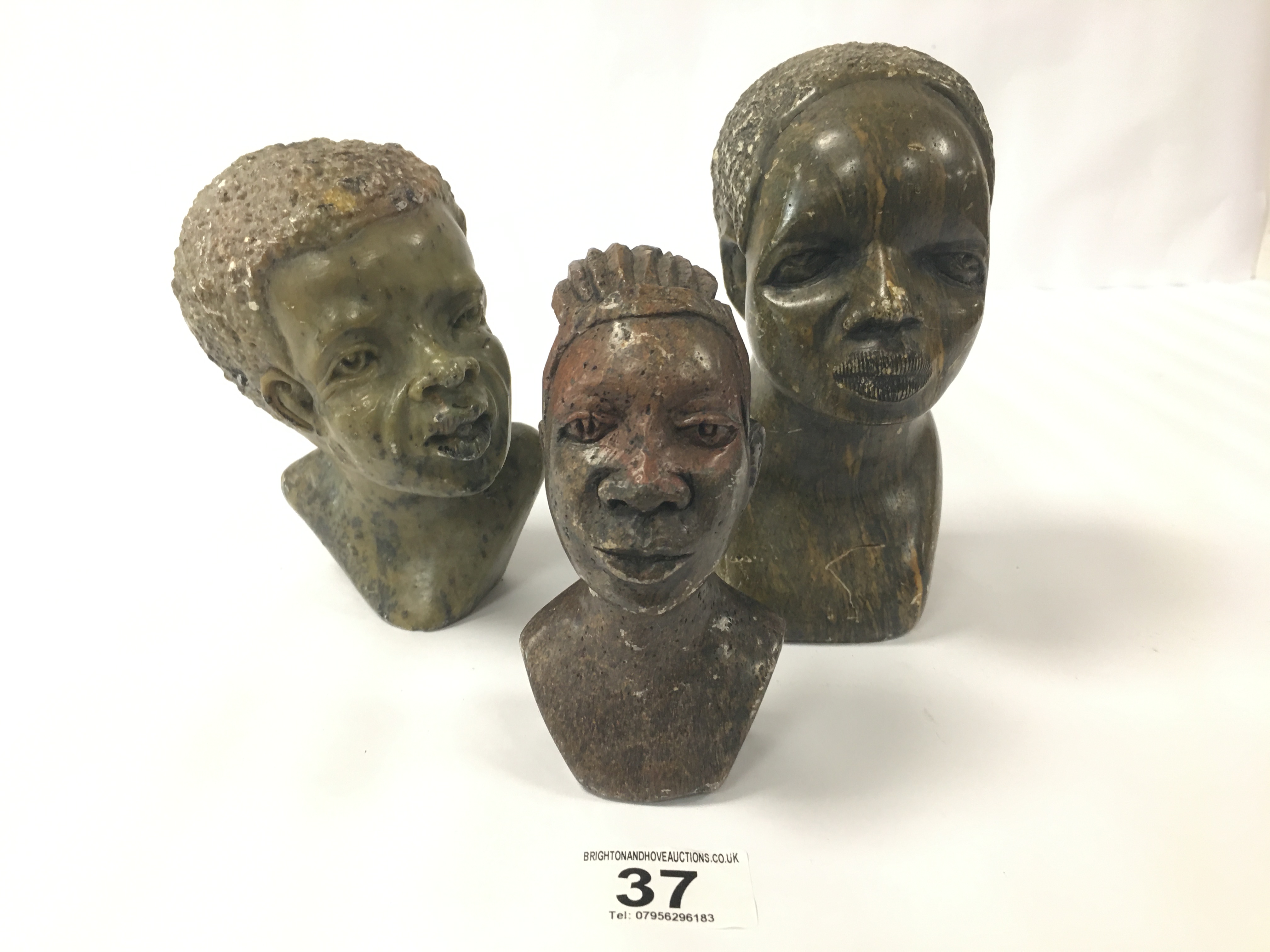 A SMALL SOAPSTONE CARVED BUST OF AN AFRICAN FIGURE, INDISTINCTLY SIGNED TO BASE, 13CM HIGH, TOGETHER