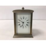 A VINTAGE BRASS CARRIAGE CLOCK WITH ARCHITECTURAL PEDIMENT, THE ENAMEL DIAL WITH ROMAN NUMERALS