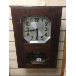 AN OAK CASED WALL CLOCK WITH SILVER COLOURED DIAL BY JURA WITH PENDULUM AND KEY 48CMS.