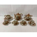 A JAPANESE KUTANI PORCELAIN TEA SET, INCLUDING A GLOBULAR TEA POT RAISED UPON FEET, CUPS AND