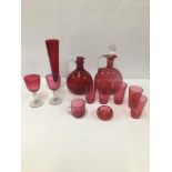 A GROUP OF CRANBERRY GLASS ITEMS, INCLUDING TWO DECANTERS AND DRINKING GLASSES, LARGEST 25.5CM HIGH